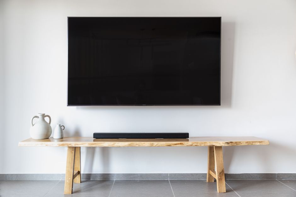 Flat-screen TV wall-mounted above a wooden console in a living room