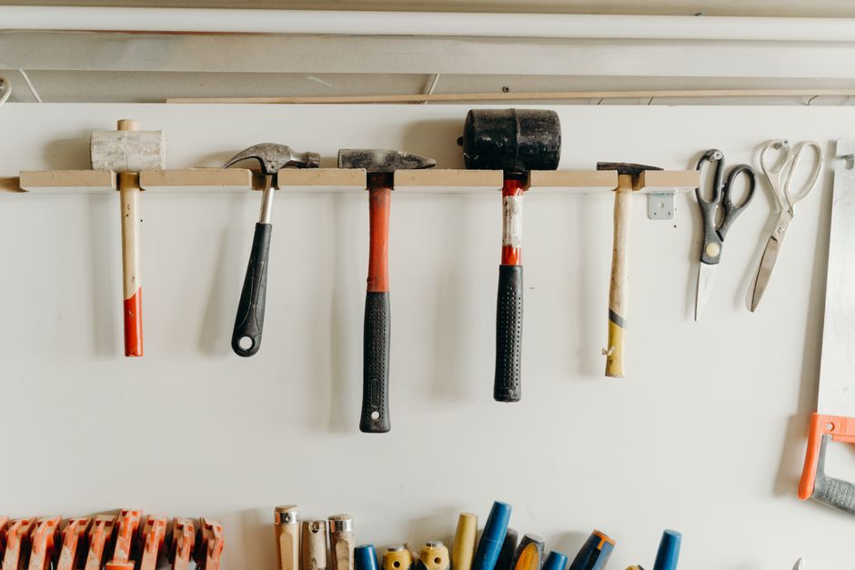 Cordless power drills lined up on a wooden workbench
